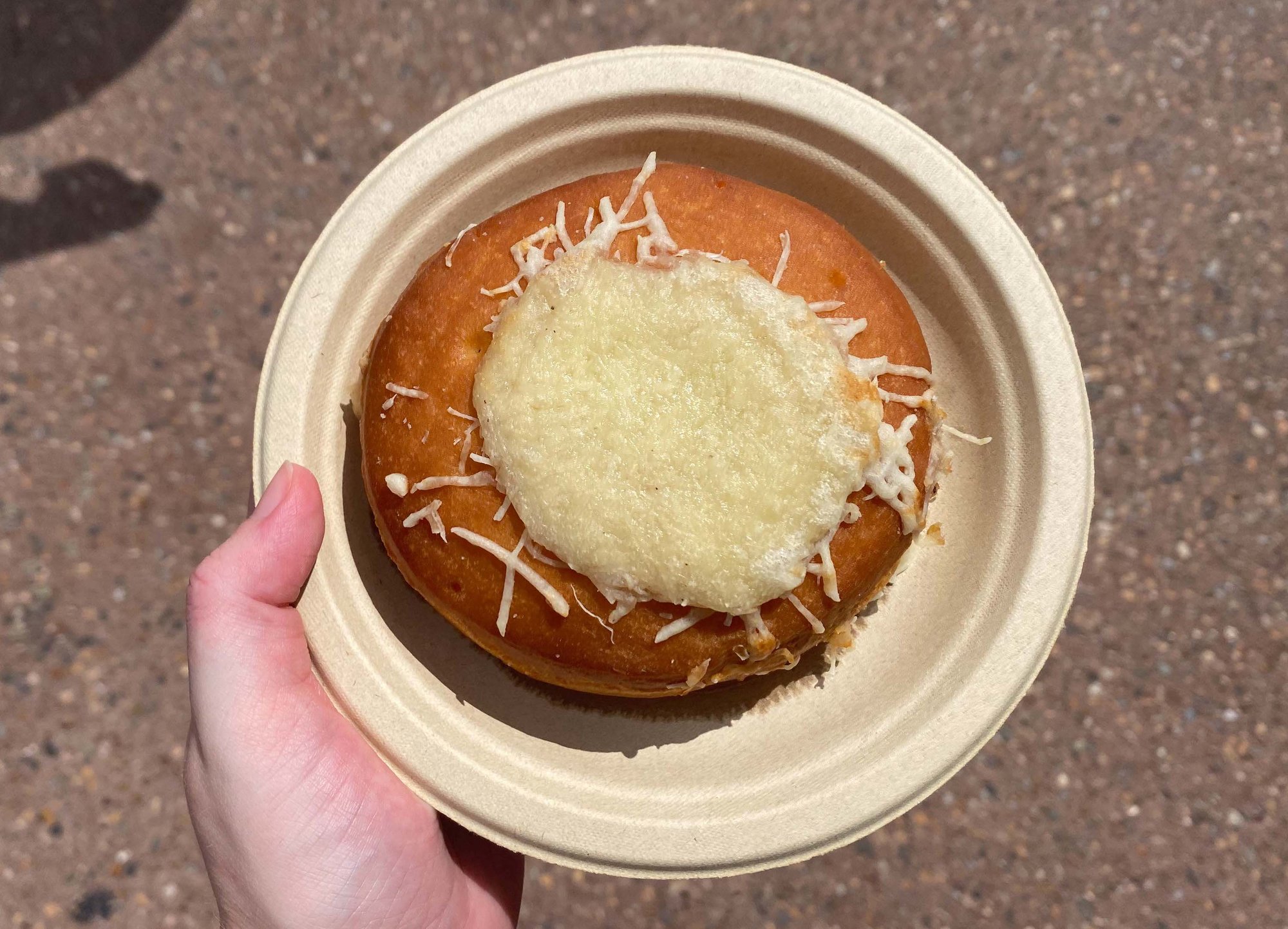 circle bread bowl with melted cheese in the center on a plate
